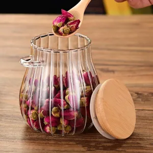 Glazen voorraadpot met houten deksel en lepel voor kruidenthee, granen en droog voedsel.