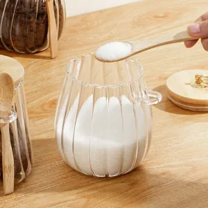 Transparante glazen voorraadpot met houten deksel en lepel voor keuken en kruidenopslag