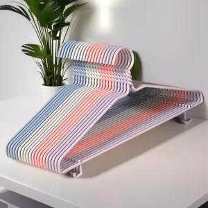 Detailgezicht van kinderkledinghangers in pastelkleurige kunststof met handige haken.