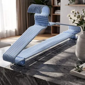 Detailopname van lichtblauwe kunststof kledinghangers met antislip schouders voor thuisgebruik