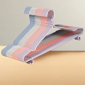 Close-up gedetailleerd overzicht van gestapelde kleurrijke kunststof kleerhangers kast.
