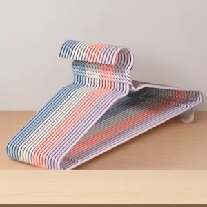 Gedetailleerd overzicht van kleurrijke plastic kledinghangers netjes op een houten tafel.