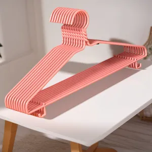 Gedetailleerd overzicht van roze kinderhangers met metalen ontwerp voor kleding drogen.
