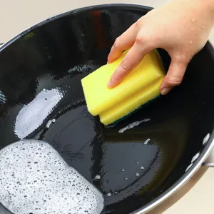 Vista detallada de una esponja de limpieza de doble cara con estropajo para la cocina.