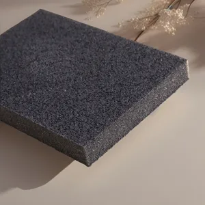 Close-up detail shot of dark grey emery cleaning sponge showing textured abrasive surface.