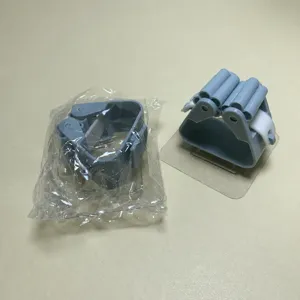 Detail view of gray wall-mounted mop holder with transparent adhesive backing and secure grip.