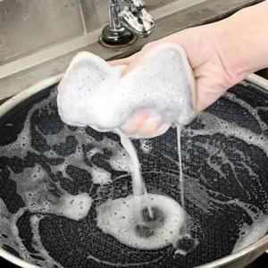 Éponge de nettoyage double face pour la cuisine, idéale pour la vaisselle et le ménage.