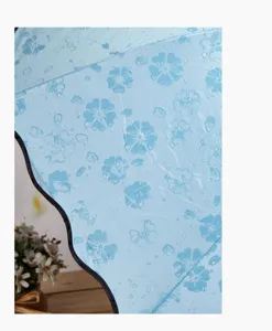 Parapluie bleu à motif floral avec effet magique d'eau et revêtement noir anti-UV élégant.