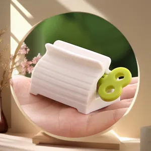 Compact Japanese style toothpaste squeezer with green wind up key for easy tube rolling and dispensing.