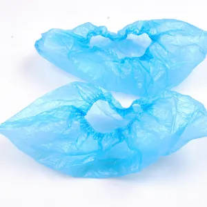 Dettaglio in primo piano di copriscarpe monouso in plastica PE blu con bordo elastico protettivo.