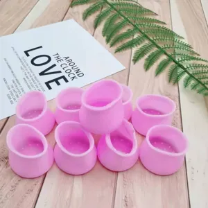 Silicone chair leg caps detail shot, pink anti-slip furniture protectors, mute floor protection.