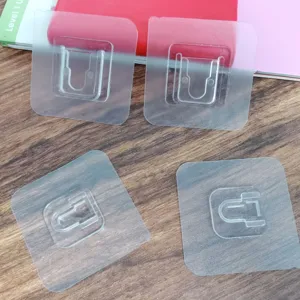Vista detallada de ganchos adhesivos transparentes para pared, soporte de plástico resistente.
