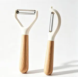 Kitchen fruit peeler detail close-up, stainless steel sharp blade with wooden handle.