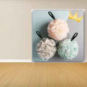 Close-up detail of three colorful mesh bath shower sponges with hanging loop, soft texture.