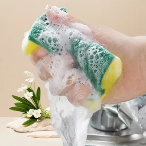Cleaning sponge detail view showing rich foam and water squeezing action in use.