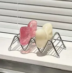 Detailansicht des Edelstahl Zickzack Seifenhalters und niedlicher Schleife im Badezimmer.