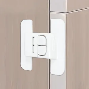 Close-up detail of the white safety lock installed on the refrigerator door surface.