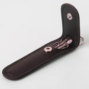 Stainless steel ear pick tool set in a dark brown leather case, detailed close-up view.