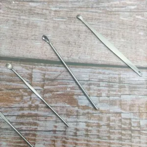 Stainless steel ear pick set detail, professional metal ear curette cleaning tool close up.