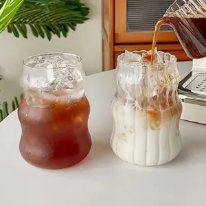 Taza de vidrio transparente en forma de nube para café, leche y jugo, diseño ondulado elegante.