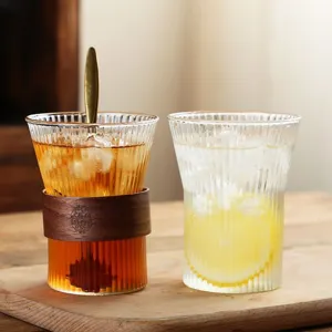 Vertical striped glass water cup with wood sleeve and spoon, elegant coffee cup.