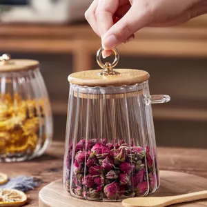 Clear glass tea jar with wooden lid and spoon for kitchen food storage and dried flower display.