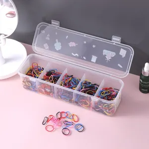 Scatola portaoggetti trasparente in plastica con elastici per capelli colorati da scrivania.