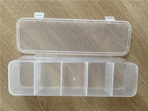 Scatola di immagazzinaggio in plastica trasparente con cinque scomparti per cavi e piccoli oggetti.