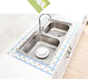 Close-up detail of kitchen sink waterproof absorbent sticker showing neat installation around basin rim.