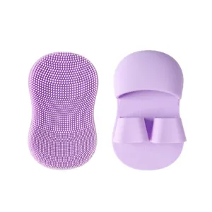 Brosse nettoyante visage en silicone violet avec prise en doigte pour exfoliation des pores.