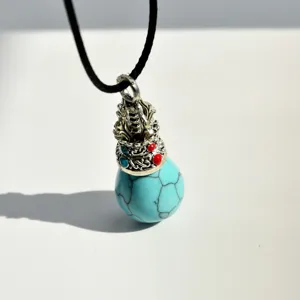 Close-up detail of the turquoise stone drop pendant with vintage Tibetan style silver crown cap.