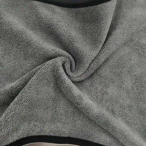 Dettaglio di panno lavaggio auto in microfibra pile corallo con tessuto grigio morbido.