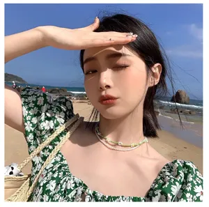 Gros plan détaillé du collier multicouche de perles et de perles de fleurs vert menthe.