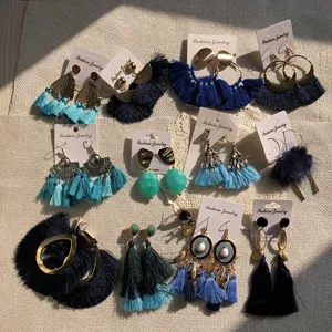 Dettaglio ravvicinato di orecchini con nappe blu dai design eleganti e colori vivaci per donna.
