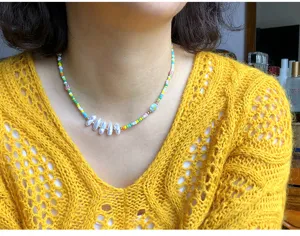 Vista di dettaglio di una collana girocollo alla moda con perline colorate e perle dolci.