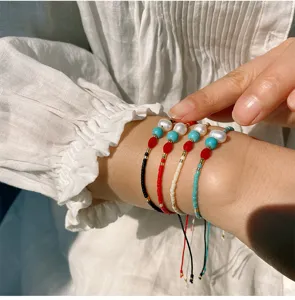 Nahaufnahme Detail handgemachter Miyuki Perlen und Süßwasserperlen Armbänder am Handgelenk.