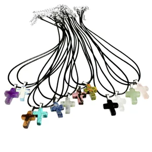 Close-up detail of multi-color crystal cross pendant necklaces on black leather cords.