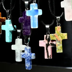 Close-up view of colorful stone cross pendants hanging with black leather cord necklaces detail.