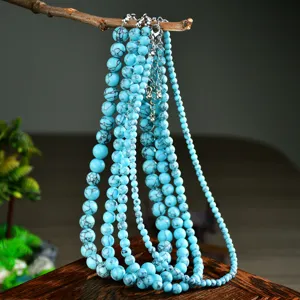 Dettaglio della collana multistrato con perline di turchese blu e catenina di prolunga.