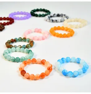 Vista dettagliata di bracciali di perle colorate in finta giada con corda elastica.
