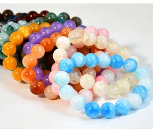 Primo piano dettagliato di bracciali di perle in finta giada colorati, impilati per le donne.