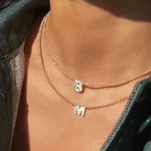 Raffinata collana di perle a doppio strato con ciondolo lettera in conchiglia estivo.