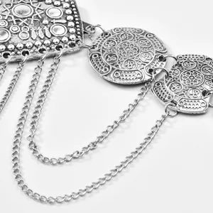 Close-up van vintage zilverkleurige metalen tailleriem met gegraveerde munten.