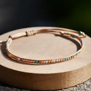 Primo piano del delicato braccialetto intrecciato di perline Miyuki su legno naturale.