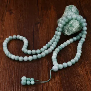 Dettaglio collana lunga con perline di preghiera in giada verde, stile etnico vintage.