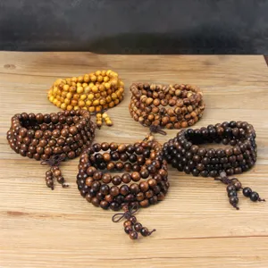 Wooden Buddhist beads bracelet detail showing various natural wood colors clearly.