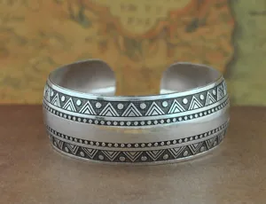 Vista dettagliata del bracciale rigido tribale in argento vintage con motivi geometrici.