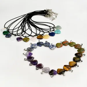 Detail view of various natural stone heart pendant necklaces with adjustable black cord chains.
