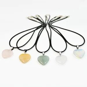 Detail shot of five heart-shaped natural stone pendant necklaces with black leather cords.