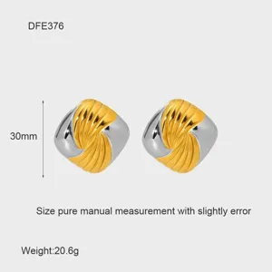 Primer plano detallado de pendientes cuadrados en espiral bicolor dorados y plateados.